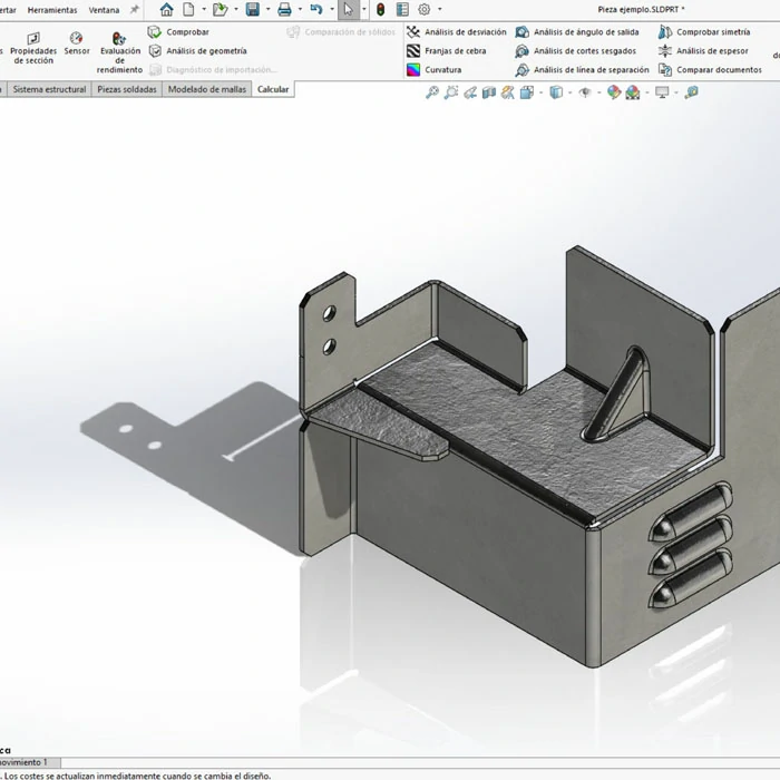Egresado sosteniendo piezas SolidWorks fabricadas en CNC